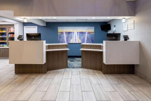a lobby with two reception desks and a tv at Baymont by Wyndham White Plains - Elmsford in Elmsford