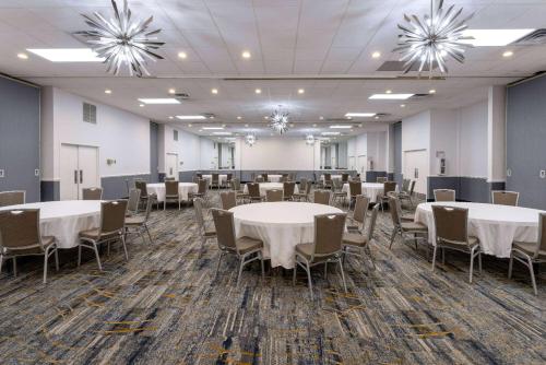 a banquet room with tables and chairs and chandeliers at Baymont by Wyndham White Plains - Elmsford in Elmsford