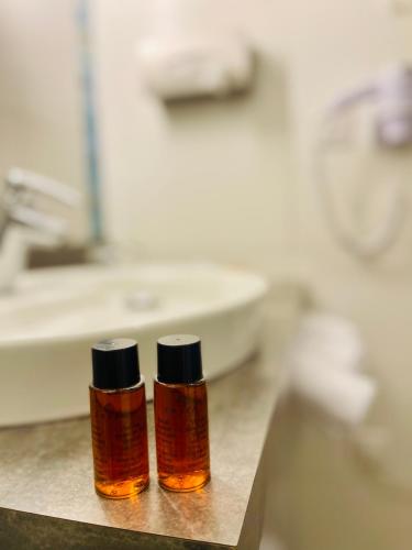 two bottles of essential oils sitting next to a bathroom sink at Au Coeur Des Bulles in Loches-sur-Ource