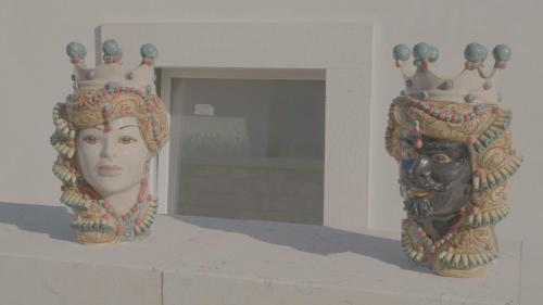 two vases with crowns and a statue of a head at B&B re apartments Palazzo Muscati in Molfetta