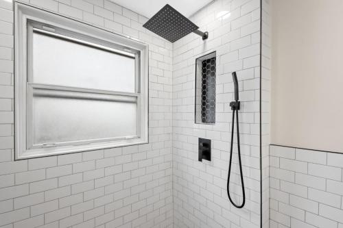 a bathroom with a shower with a window at The Lakewood Belle: Family Friendly Home 10 minutes to Downtown! in Cleveland
