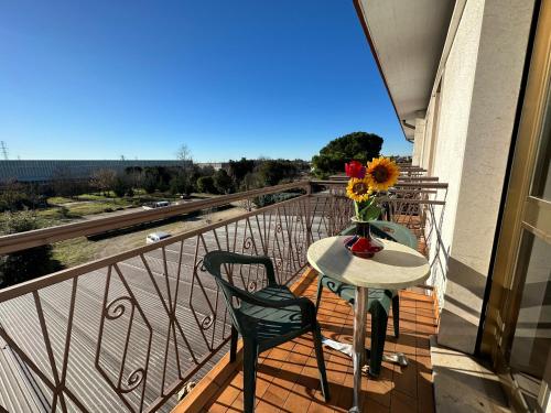 un tavolo e sedie su un balcone con un vaso di fiori di Hotel Miura a Cavalcaselle