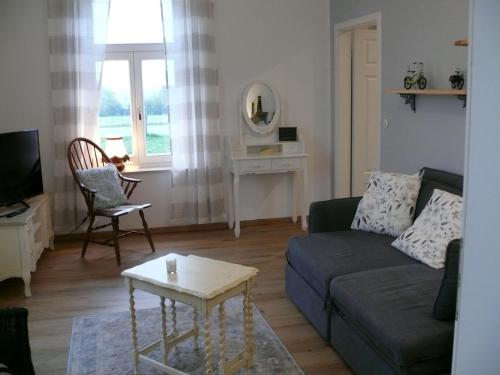 uma sala de estar com um sofá e uma mesa em Landlust Unser L ieblingscafe em Xanten