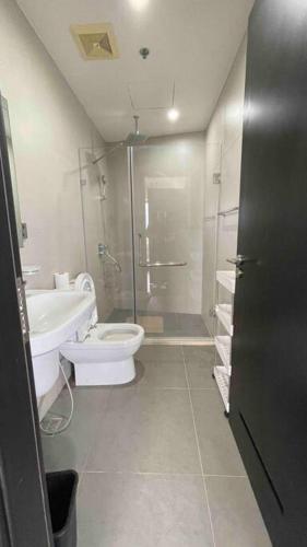 a bathroom with a shower and a toilet and a sink at Homey Comfy CondoTel - AEON Towers Davao in Davao City