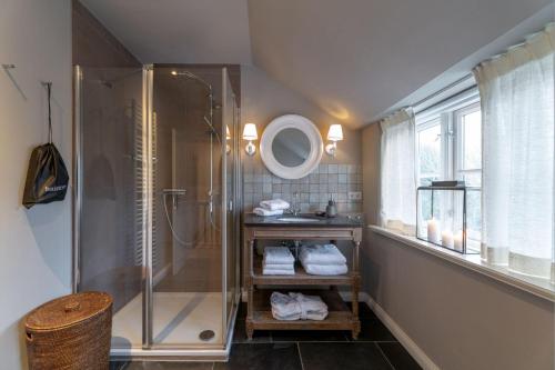 a bathroom with a shower and a sink and a mirror at von-Deska-Countryhouses-Reeder-Fluegel in Nieblum