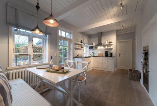 een keuken met een tafel en stoelen in een kamer bij von-Deska-Countryhouses-Kapitaens-Fluegel in Nieblum