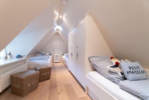 a attic bedroom with a bed and a bathroom at von-Deska-Countryhouses-Reeder-Fluegel in Nieblum