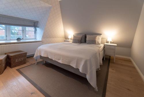 a bedroom with a bed with two lamps on it at von-Deska-Countryhouses-Kapitaens-Fluegel in Nieblum