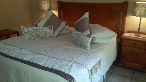 a bedroom with a bed with white sheets and pillows at Harmony Guesthouse in Nelspruit
