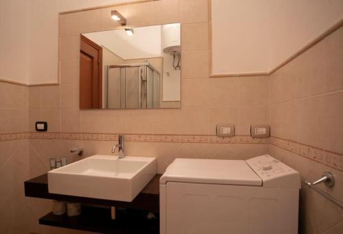 La salle de bains est pourvue d'un lavabo et d'un miroir. dans l'établissement Esperanto Suite&Pool, à Favignana
