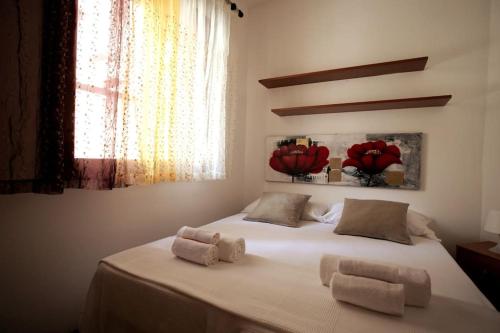 una camera da letto con un grande letto bianco con due cuscini di Esperanto Suite&Pool a Favignana