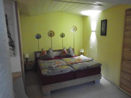 ein Schlafzimmer mit einem Bett in einer gelben Wand in der Unterkunft Apartment Regina in Laucha