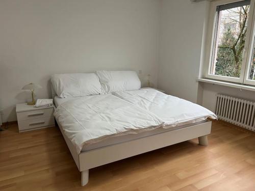 a bedroom with a bed with white sheets and a window at Castle View Big Appartment Vaduz Center in Vaduz