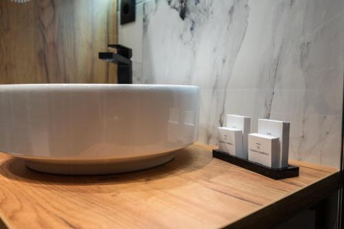 a white sink sitting on top of a wooden counter at DMS Apartments & Suites Sarajevo in Vogošća