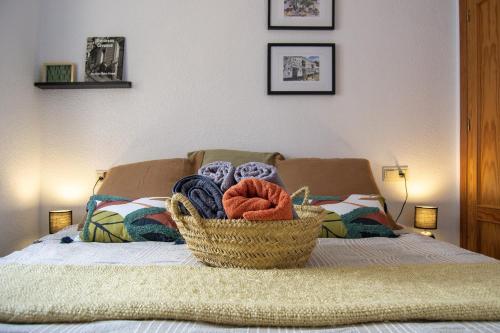 uma cesta de toalhas em cima de uma cama em Casa típica y terraza, maison andalouse, typical house with rooftop em Almuñécar