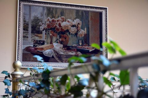 a picture of a vase of flowers in a painting at Atrium Hotel in Ivano-Frankivsʼk