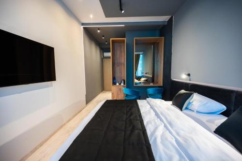 a hotel room with a bed and a television at DMS Apartments & Suites Sarajevo in Vogošća