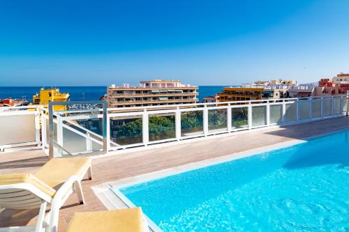 a swimming pool on the roof of a building with the ocean at Apartamentos Park Plaza in Puerto de la Cruz