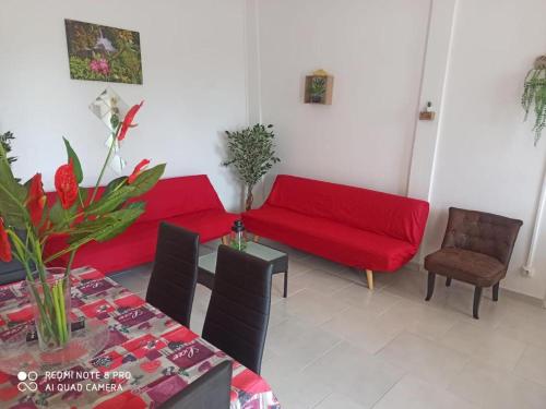 a living room with a red couch and a table at L'étonnant F3 Joris in Saint-Pierre