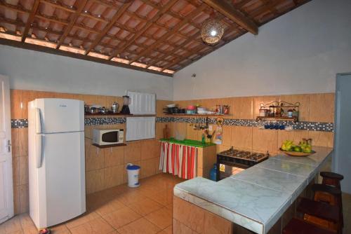a kitchen with a white refrigerator and a counter at Casa de Praia Caminho das Indias in Coroa Vermelha