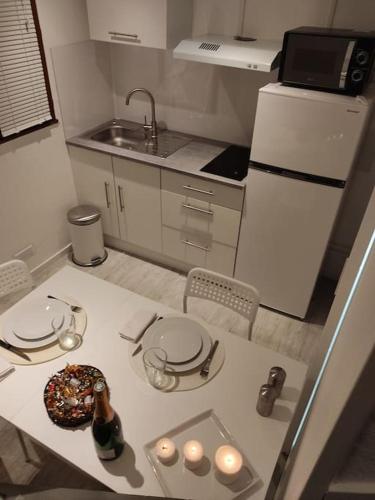 - une petite cuisine avec une table et un donut dans l'établissement Studette Rémoise, à Reims