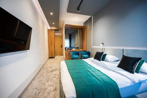 a hotel room with a bed and a tv at DMS Apartments & Suites Sarajevo in Vogošća