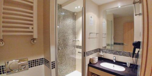 Un baño con lavabo, ducha y espejo. en Angella KOP Konaci, en Kopaonik
