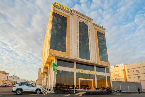 a car parked in front of a large building at Najm aris hotel in Tabuk