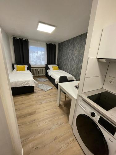 Habitación pequeña con 2 camas y cocina en Apartment 33, en Bad Hönningen