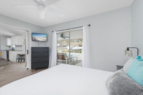 Habitación blanca con cama y balcón. en Villa Ventura, en Butler Beach