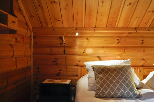 a bedroom with a bed with a wooden wall at Villa Franca Maria in Rättvik