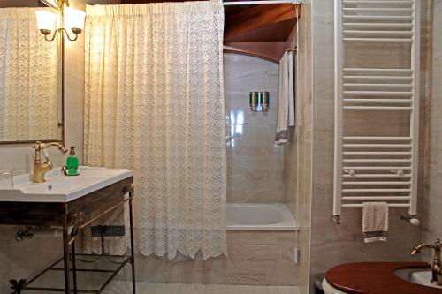 La salle de bains est pourvue d'une douche, d'un lavabo et d'une baignoire. dans l'établissement Casa Rural Juliana, 