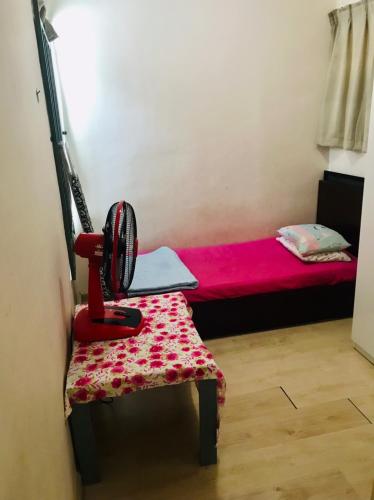Zimmer mit einem roten Bett und einem roten Stuhl in der Unterkunft KADDU Homestay in Kota Kinabalu