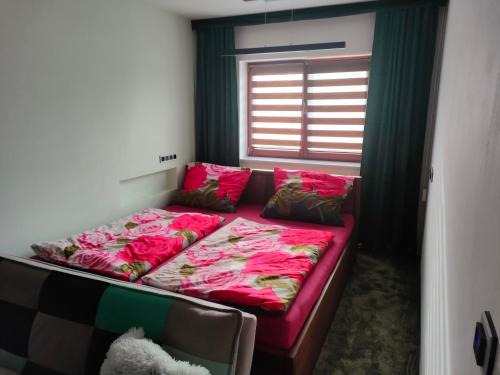 een slaapkamer met een bed met roze lakens en een raam bij Apartmán uprostřed trojúhelníku Praha - Karlovy Vary - Plzeň in Kolešovice