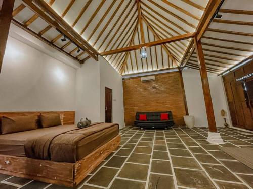 a bedroom with a bed and a suitcase in it at Villa Kamar Tamu Piyungan in Bantul