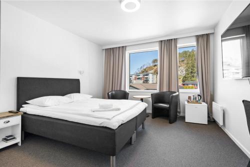 Habitación de hotel con cama, mesa y sillas en Kinn Hotell Florø, en Florø