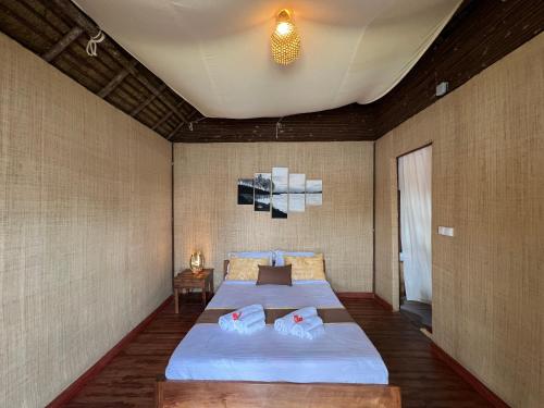 a bedroom with a large bed with two pillows on it at TSIAZOMPANIRY ISLAND LODGE 