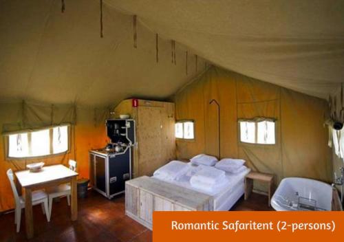 a bedroom with a bed and a stove in a tent at Safaritents & Glamping by Outdoors in Holten