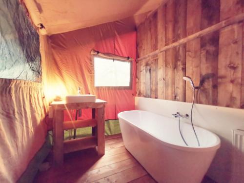 a bathroom with a white tub and a sink at Glamping in Nature by Outdoors in Holten