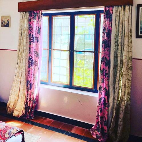 a window with curtains in a living room at Villa Jacaranda in Varkala