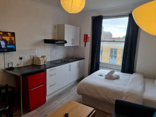 a room with a kitchen with a bed and a table at Chic & Modern Studio in Caledonian Rd in London
