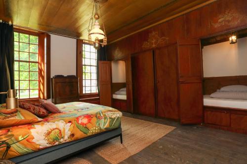een slaapkamer met een bed in een kamer met houten wanden bij Hoogheem Erfgoed & Logies in Nieuwolda