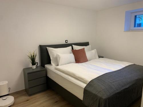 1 dormitorio con 1 cama con sábanas y almohadas blancas en Pine Tree Holiday House en Gozd Martuljek