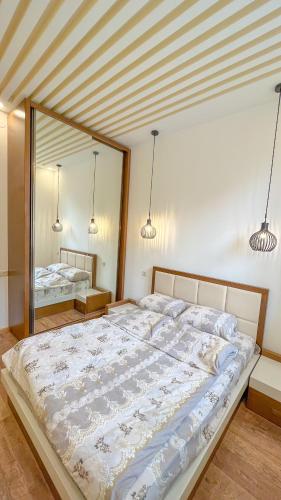 a large bed in a bedroom with a large mirror at Новая квартира у Площади in Yerevan