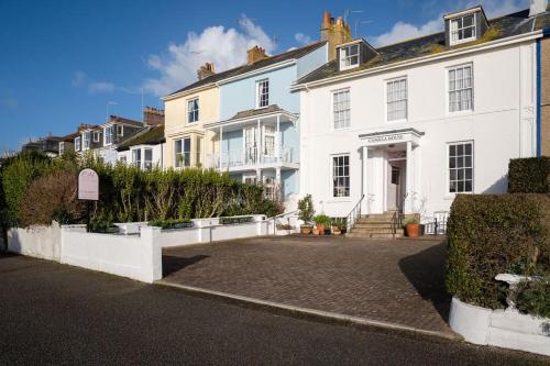 a white house with a driveway in front of it at Camilla House Guest House in Penzance