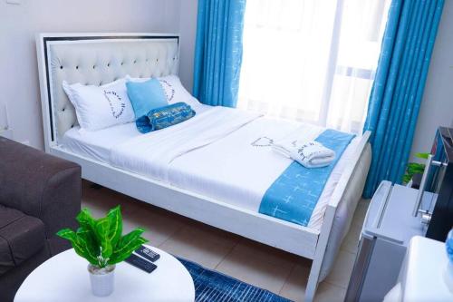 a bedroom with a bed and a couch and a table at LaMeg2 Furnished Studio with Pool - Kiambu Rd in Nairobi