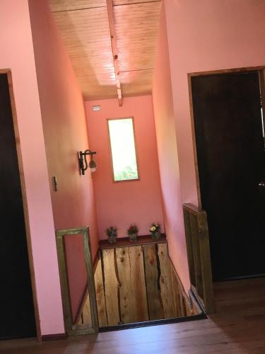a hallway with pink walls and a wooden door at Casa Lago Caburgua in Pucón