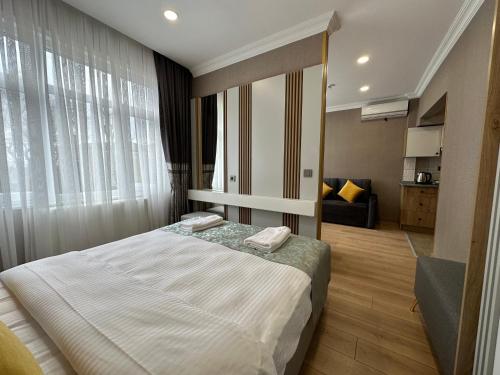 a bedroom with a large bed and a living room at H&L Suites in Istanbul