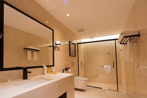 a bathroom with a shower and a sink and a mirror at Aris Star in Tabuk