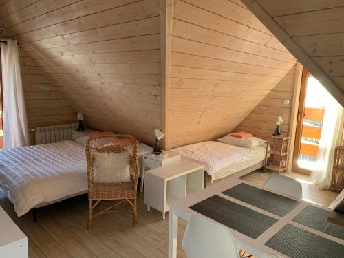ザコパネにあるNoclegi Zakopane Krzesanicaのベッド2台とデスクが備わる屋根裏部屋